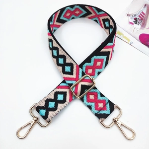 Detail of bohemian geometric jacquard bag strap with gold metal buckles and clips