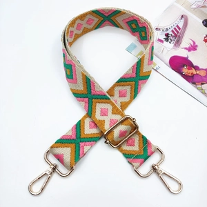 Detail of adjustable wide colorful woven strap with geometric jacquard and golden lobster clasps