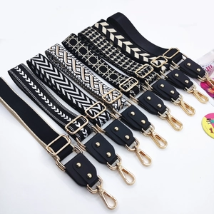Detail view of various ethnic jacquard bag straps with gold lobster clasps and leather ends