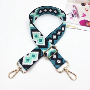 Close-up of geometric jacquard shoulder strap with golden metal lobster clasps