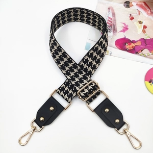Adjustable wide jacquard bag strap with black houndstooth pattern and gold rivets