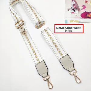 Detail of detachable phone strap and wristlet with golden chevron pattern and metal hooks