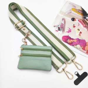 Green leather coin purse with striped crossbody strap and three zipper compartments