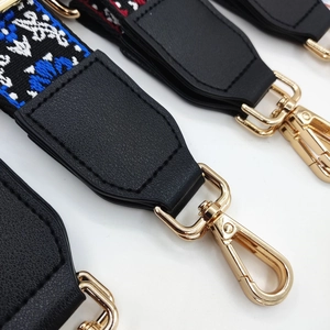 Close-up of ethnic style embroidered bag strap with leather end and gold metal clasp