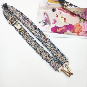 Detail view of adjustable tweed shoulder strap with gold metal hooks and leather connectors