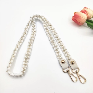 Détail de la bandoulière tressée avec perles blanches et fermoir mousqueton doré
