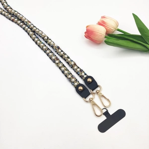 Détail de la bandoulière de téléphone en tweed et perles avec fermoir doré et carte
