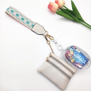 Detail of bohemian woven strap and beige lychee pattern double zipper coin purse with charms