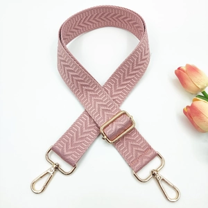 Close-up of herringbone woven bag strap in dusty rose with adjustable gold metal buckle