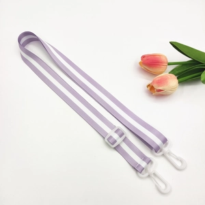 Detail view of purple and white striped strap with white plastic hooks and adjustable buckle