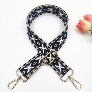 Detail of ethnic style woven strap with geometric patterns and golden metal lobster clasps