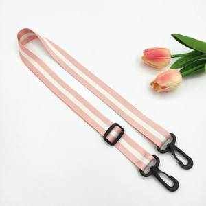 Detail of pink polyester bag strap with white stripes and black plastic swivel hooks