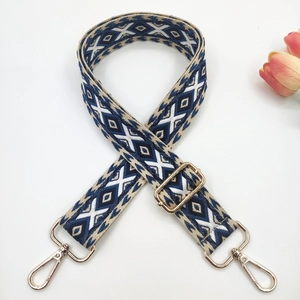 Detail of bohemian geometric woven bag strap with gold lobster clasps and diamond pattern