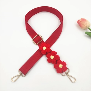 Detail of red floral woven strap with handmade crochet flowers and gold lobster clasps