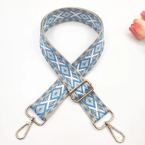 Close-up of bohemian geometric woven bag strap with golden metal lobster clasps