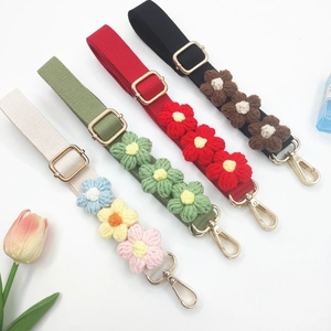 Detailed view of adjustable crochet flower bag straps in beige, green, red, and black colors