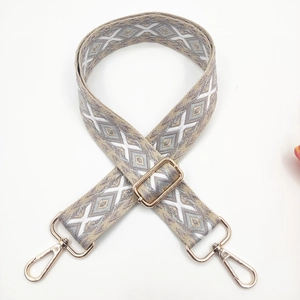 Detail of adjustable bohemian embroidered bag strap with golden metal lobster clasps