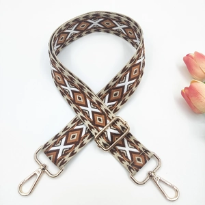Close-up of geometric jacquard bag strap with golden hardware and floral decor