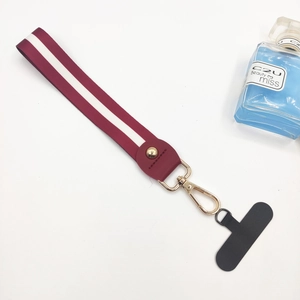 Detail of red and white striped wrist strap with gold buckle and phone connector