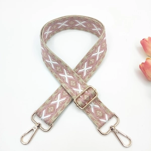 Detail view of adjustable pink ethnic bag strap with embroidery and gold lobster hooks
