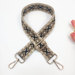 Close-up of ethnic geometric embroidered bag strap with golden metal swivel hooks