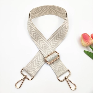 Close-up of adjustable woven arrow pattern shoulder strap with golden swivel snap hooks