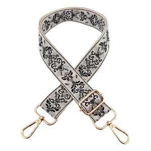 Close-up of ethnic jacquard strap with black floral pattern and gold metal buckles