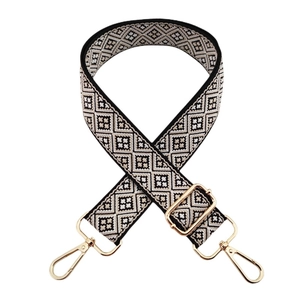 Macro shot of ethnic geometric jacquard bag strap with gold lobster clasps and buckles