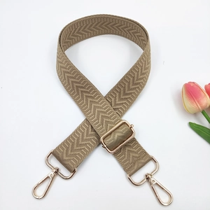 Detail of adjustable khaki chevron woven strap with polished gold lobster clasps
