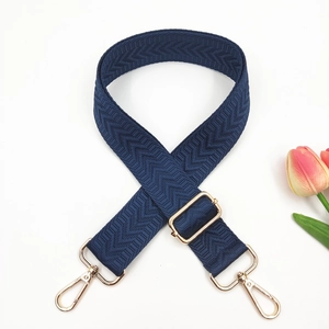Detail of navy blue adjustable strap with golden hardware and herringbone weave texture