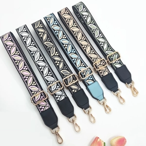 Detail view of ethnic embroidery bag straps with golden metal buckles in various colors
