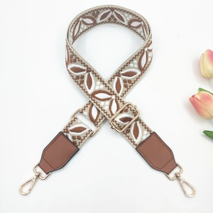 Close-up of wide bohemian floral embroidered purse strap with golden metal swivel hooks