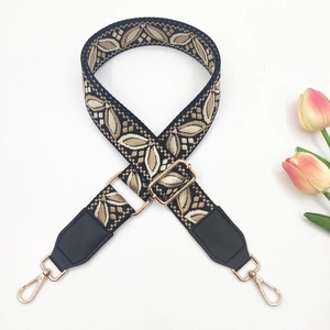 Close-up of ethnic jacquard wide bag strap with leaf patterns and gold metal hardware