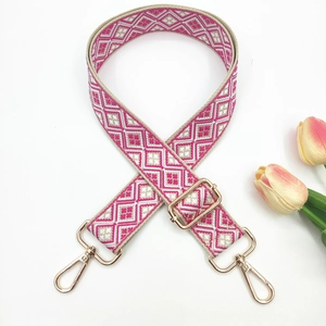 Detail of colorful geometric jacquard strap with gold-tone lobster clasps and buckles