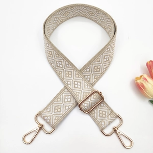 Macro view of adjustable 3.8cm woven shoulder strap with gold metal buckles and pattern