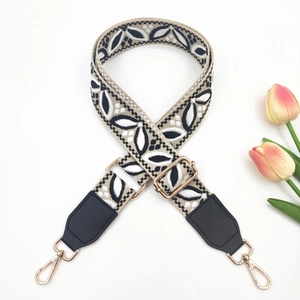 Detail of wide ethnic woven strap with leaf pattern and gold-tone metal buckles