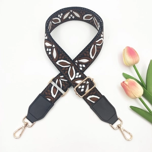 Close-up of ethnic geometric woven bag strap with golden metal lobster clasps
