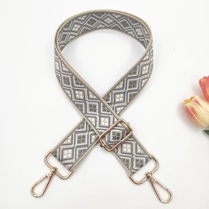 Close-up of adjustable geometric weave handbag strap with gold-tone hardware and tulip