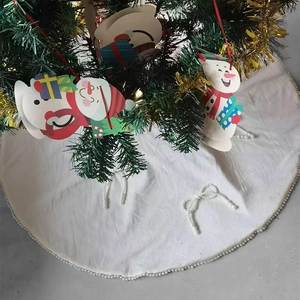 White Christmas tree skirt with pearl trim and snowman hangings for holiday decoration