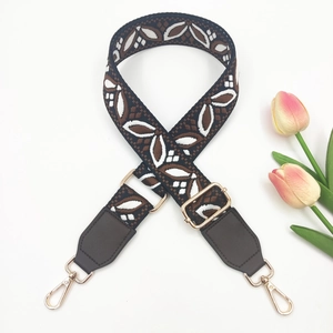 Detail of bohemian wide jacquard guitar strap with floral pattern and gold metal hooks