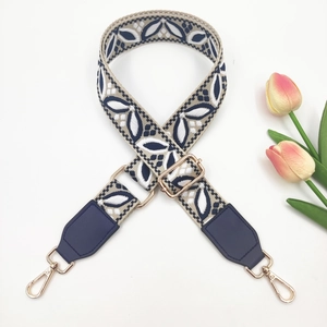 Detail of blue and white ethnic jacquard strap with gold metal hooks and tulip decor