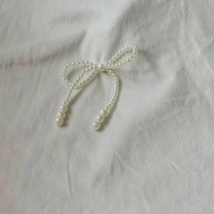 Close-up of white faux pearl bow Christmas tree skirt with elegant bead details