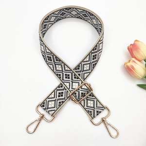 Detail of adjustable geometric patterned woven strap with high-gloss gold metal buckles