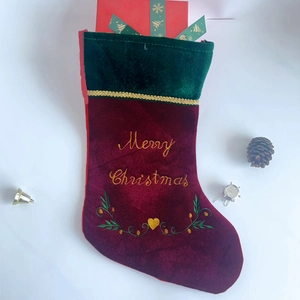 Classic red and green velvet Christmas stocking with golden Merry Christmas embroidery