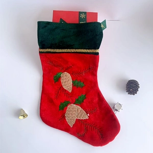 Classic red and green Christmas stocking with pine cone embroidery and gold wavy trim