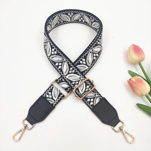 Detail of adjustable wide shoulder strap with black and white floral leaf embroidery