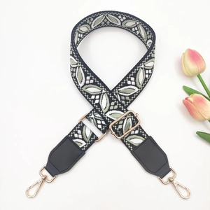Macro shot of ethnic pattern strap with adjustable metal buckle and leather ends