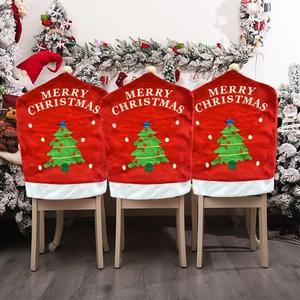 Three red flannel Christmas chair covers with embroidered trees and Merry Christmas text