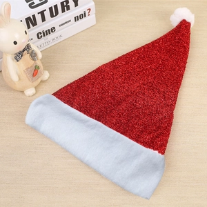 Sparkly red sequin Christmas hat with white plush trim and pompom on wooden background