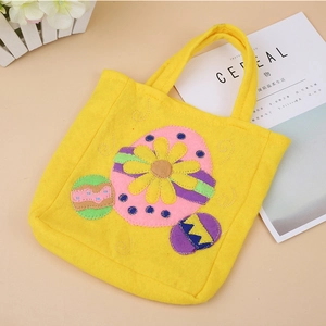 Détail du sac cadeau en feutre jaune avec broderie d'œuf de Pâques et motif tournesol